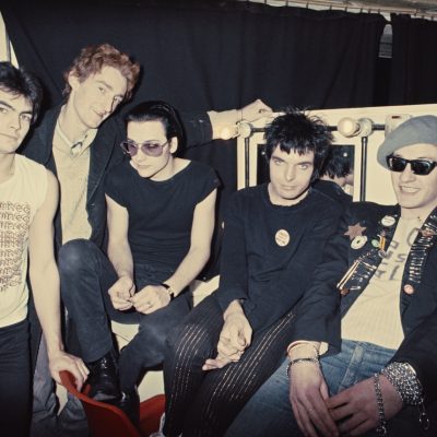 Group portrait of an early line up of punk band The Damned backstage, London, 1977. L-R Jon Moss (later of Culture Club), Lu Edmonds, Dave Vanian, Brian James and Captain Sensible. (Photo by Erica Echenberg/Redferns)