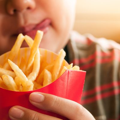 Closeup of kid holding french fries packet